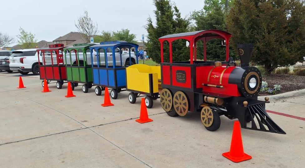 Families watching and waving as the Choo Choo Express trackless train passes by